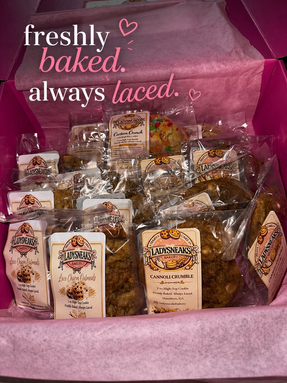 A pink LadySneaks Bakery box filled with individually packaged cookies